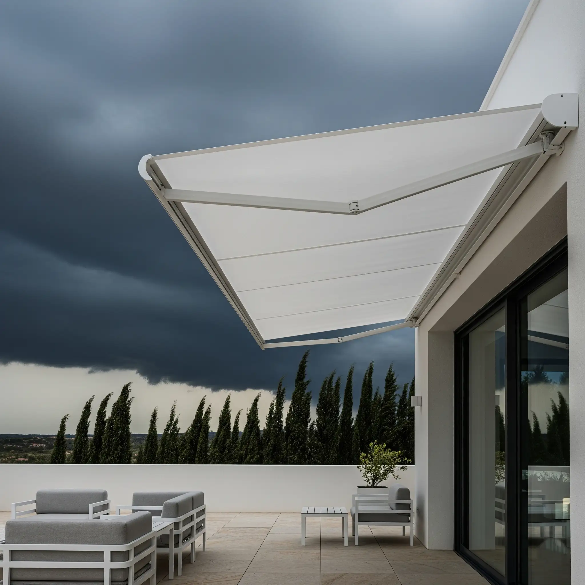 Toldo articulado moderno recogiéndose de forma automática ante la llegada de un frente de tormenta con nubes oscuras, resaltando la importancia de una detección rápida para evitar daños estructurales.